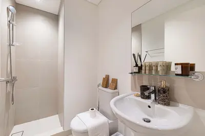a bathroom with a toilet and a sink and a shower at Luxury 4BR Burj Khalifa Opera District in Dubai