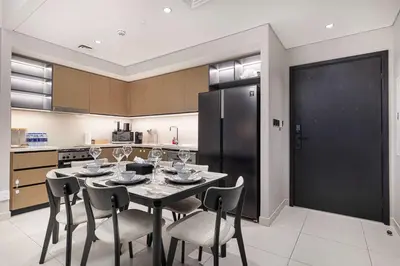 a kitchen with a table with chairs and a refrigerator at Luxury 4BR Burj Khalifa Opera District in Dubai