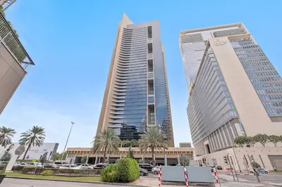 two tall buildings in a city with palm trees at Silkhaus Modern Studio in Sky Gardens Tower DIFC in Dubai