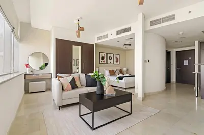 a living room with a couch and a table at Silkhaus Modern Studio in Sky Gardens Tower DIFC in Dubai