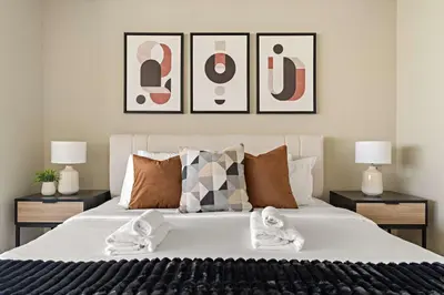 a bedroom with a large bed with three pictures on the wall at Silkhaus Modern Studio in Sky Gardens Tower DIFC in Dubai