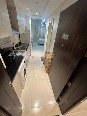 a small kitchen with a sink and a stove at Carson Tower- A Damac Hills 1, Studio Apartment in Dubai