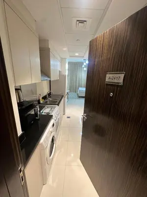 a kitchen with a door with an exit sign on it at Carson Tower- A Damac Hills 1, Studio Apartment in Dubai