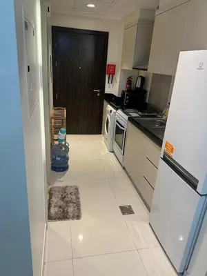 a kitchen with a refrigerator and a stove top oven at Carson Tower- A Damac Hills 1, Studio Apartment in Dubai
