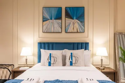 a bedroom with a large bed with three pictures on the wall at Modern 1 bedroom with Direct Marina Access in Dubai
