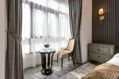 a bedroom with a table and a chair and a window at Souk Al Bahar Lavish 1-bedroom apartment with Burj Khalifa view at your doorstep by Norbu Holiday Homes in Dubai