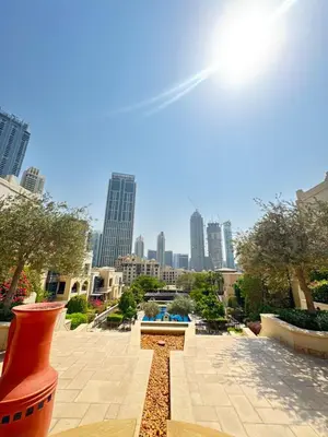 a view of a park with a city in the background at Souk Al Bahar Lavish 1-bedroom apartment with Burj Khalifa view at your doorstep by Norbu Holiday Homes in Dubai