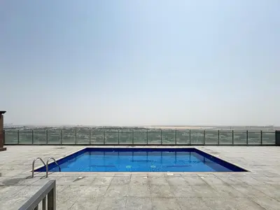 a swimming pool with a view of the beach at Modern 2BR in Ikarus Tower, Dubai Production City in Dubai
