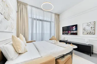 a bedroom with a large bed and a tv at Modern 2BR in Ikarus Tower, Dubai Production City in Dubai