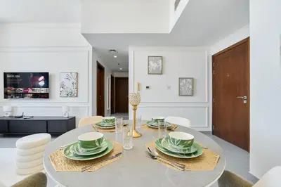 a dining room with a table and chairs at Modern 2BR in Ikarus Tower, Dubai Production City in Dubai