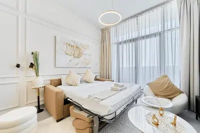 a white room with a bed and a couch at Modern 2BR in Ikarus Tower, Dubai Production City in Dubai