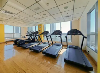 a row of treadmills in a gym with windows at New Modern Marina View Apartment in Bay Central in Dubai