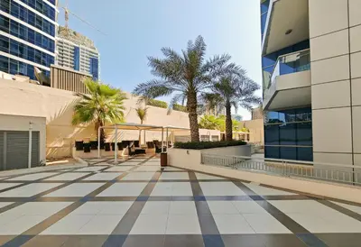 a walkway in a city with palm trees and buildings at New Modern Marina View Apartment in Bay Central in Dubai