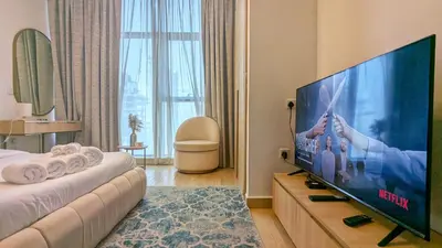 a hotel room with a large flat screen tv at Modern Apartment in Regina Tower JVC - Easy Access to JBR, Circle Mall & Dubai Hills Mall in Dubai
