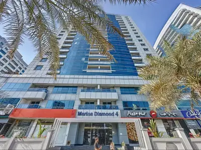 a tall building with palm trees in front of it at Vogue Marina Diamond Near JBR Beach and Marina Mall, One Bedroom Apartment with Balcony and City View, Access to all Amenities, Walkable to Sobha Realty Metro Station and Bus Stop in Dubai