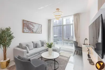 a living room with a couch and a table at Vogue Marina Diamond Near JBR Beach and Marina Mall, One Bedroom Apartment with Balcony and City View, Access to all Amenities, Walkable to Sobha Realty Metro Station and Bus Stop in Dubai