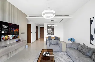 a living room with a couch and a table at Sobha Hartland, Green building2 1BR in Dubai