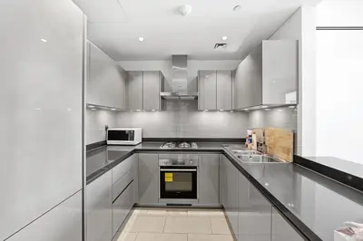 a large kitchen with stainless steel cabinets and appliances at Sobha Hartland, Green building2 1BR in Dubai