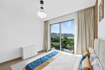 a bedroom with a bed and a large window at Sobha Hartland, Green building2 1BR in Dubai