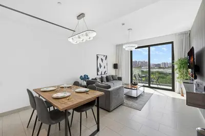 a living room with a table and a couch at Sobha Hartland, Green building2 1BR in Dubai
