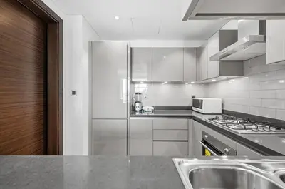 a kitchen with stainless steel appliances and a sink at Sobha Hartland, Green building2 1BR in Dubai