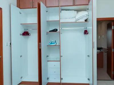 a walk in closet with white doors and shelves at Bright & Spacious 2BR Apartment | The Greens Community in Dubai