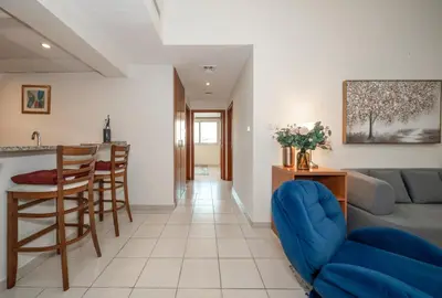 a living room with a couch and a table at Bright & Spacious 2BR Apartment | The Greens Community in Dubai