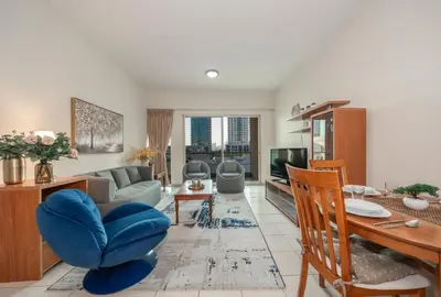 a living room with a couch and a table at Bright & Spacious 2BR Apartment | The Greens Community in Dubai