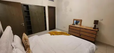 a bedroom with a bed and a dresser and a mirror at Lofts West Tower - Downtown by Golden Casa in Dubai