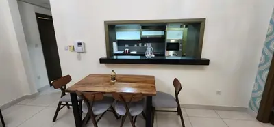 a dining room with a wooden table and chairs at Lofts West Tower - Downtown by Golden Casa in Dubai