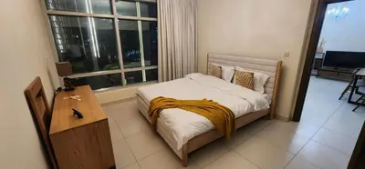 a bedroom with a bed and a large window at Lofts West Tower - Downtown by Golden Casa in Dubai