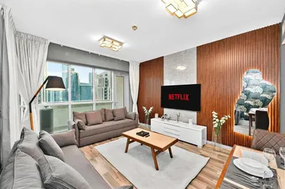 a living room with a couch and a table at Lux 1BR & Steps to Dubai Mall & Burj Khalifa in Dubai