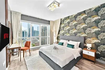 a bedroom with a king sized bed and a large window at Lux 1BR & Steps to Dubai Mall & Burj Khalifa in Dubai