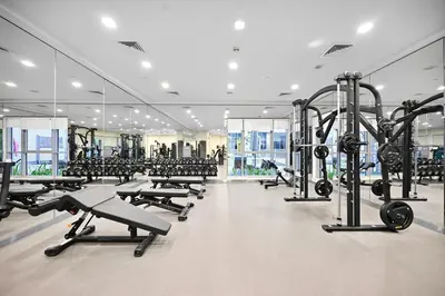 a gym with a lot of treadmills and machines at Lux 1BR & Steps to Dubai Mall & Burj Khalifa in Dubai