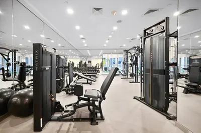 a gym with rows of treadmills and machines at Lux 1BR & Steps to Dubai Mall & Burj Khalifa in Dubai