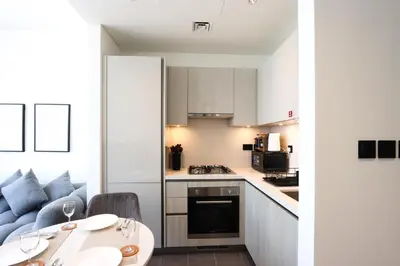 a small kitchen with a table and a couch at Stylish 1BR with Skyline Views Sobha Crest, Hartland in Dubai