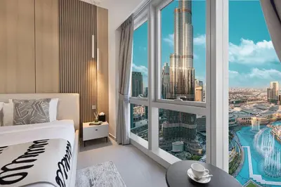 a bedroom with a large window with a view of a city at Luxury 4BR Burj View Steps from Dubai Mall in Dubai