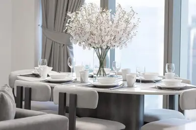 a dining room table with a vase of flowers on it at Luxury 4BR Burj View Steps from Dubai Mall in Dubai