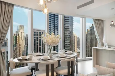 a dining room with a table and chairs and large windows at Luxury 4BR Burj View Steps from Dubai Mall in Dubai