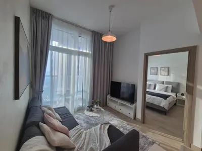 a living room with a couch and a large mirror at Modern one bedroom in marina in Dubai