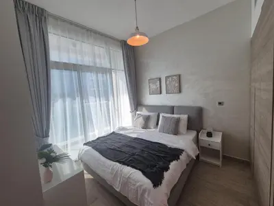 a bedroom with a bed and a large window at Modern one bedroom in marina in Dubai