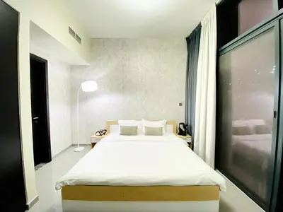 a bedroom with a large bed and a window at Bright & Cozy 1BR in Business Bay with Skyline Views in Dubai