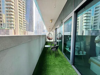 a balcony with green grass on the side of a building at Bright & Cozy 1BR in Business Bay with Skyline Views in Dubai