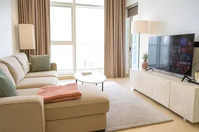 a living room with a couch and a tv at Luxury 1BR with Marina Views Swimming Pool Gym in Dubai