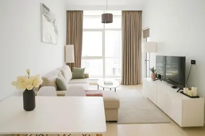 a white living room with a couch and a tv at Luxury 1BR with Marina Views Swimming Pool Gym in Dubai