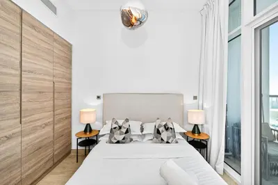 a bedroom with a bed and two tables with lamps at Dubai Marina Living 1BR near JBR in Dubai