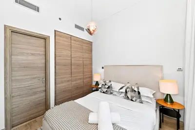 a bedroom with a large bed with a wooden headboard at Dubai Marina Living 1BR near JBR in Dubai