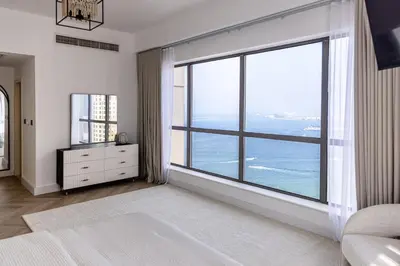 a bedroom with a large window with a view of the ocean at Amazing 2 bedroom with Sea view ! Rimal ! in Dubai