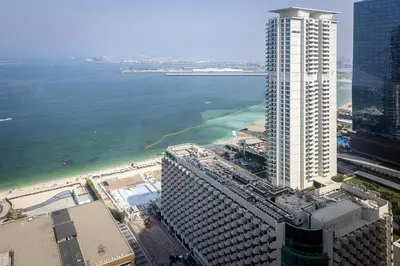 an aerial view of the ocean and a tall building at Amazing 2 bedroom with Sea view ! Rimal ! in Dubai
