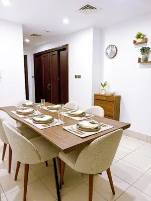 a dining room with a wooden table and chairs at Premium1BR Retreat with Burj Khalifa View in Dubai